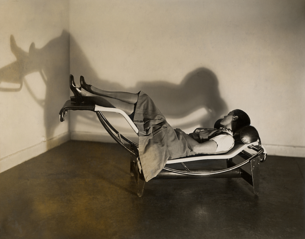 Charlotte Perriand sdraiata sull’iconica chaise longue in tubo d’acciaio, opera sua, di Le Corbusier e Pierre Jeanneret, 1929 © Perriand e Jeanneret, VG Bild-Kunst. Bonn 2021, © Le Corbusier: F.L.C./VG Bild-Kunst, Bonn 2021