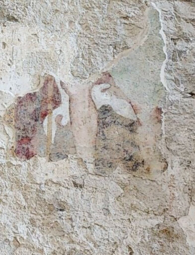 Frammento di affresco cinquecentesco raffigurante la parte inferiore di un san Rocco, con mantello e bastone. Il
dipinto murale è visibile nei pressi della posizione originaria dell’altare della Resurrezione.